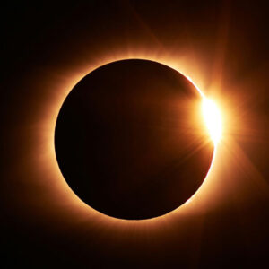 Eclipse solar total en el momento del efecto anillo de diamantes, con la luna cubriendo el disco solar y un destello de luz radiante.